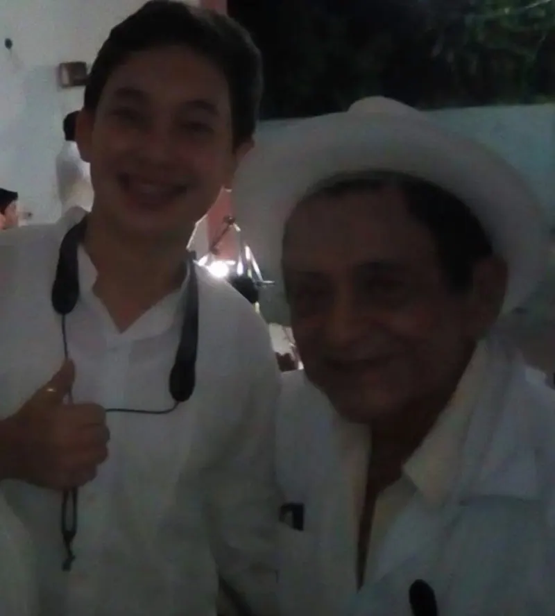 Un joven integrante junto al maestro Eufrasio Pech, con sombrero
